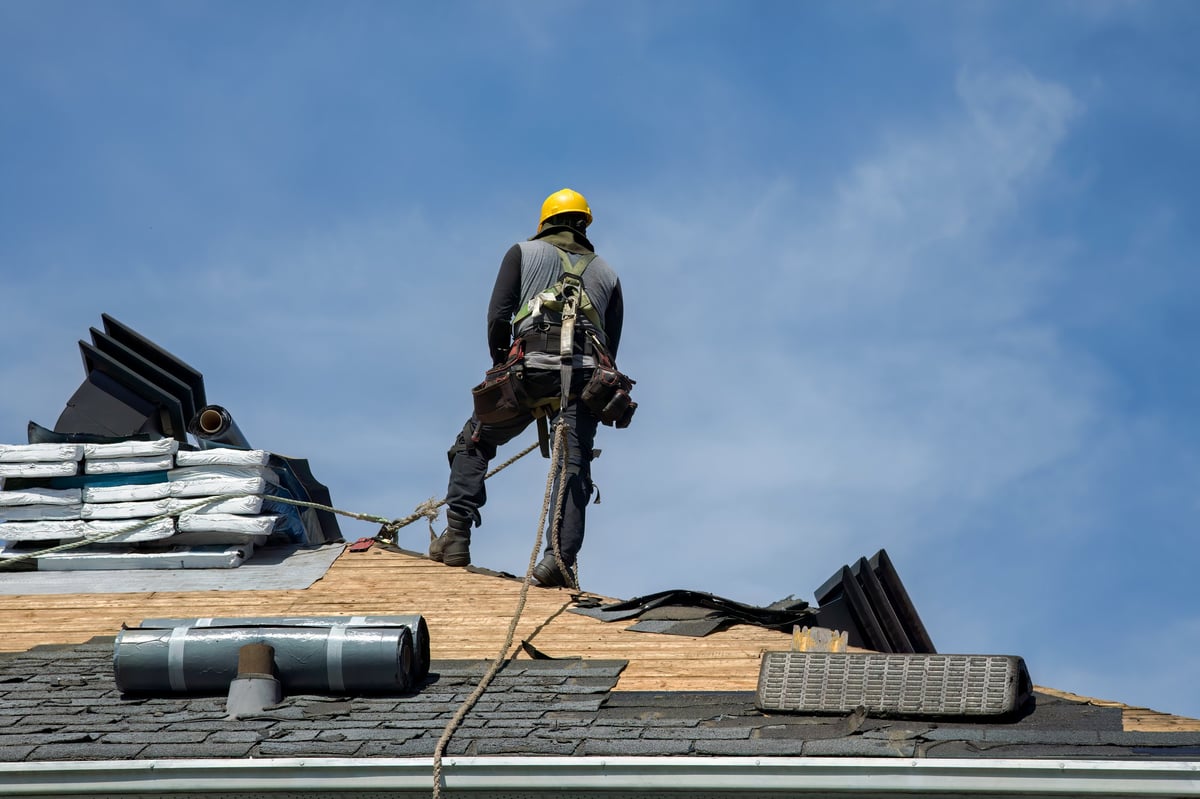 Construction worker installing roofing materials